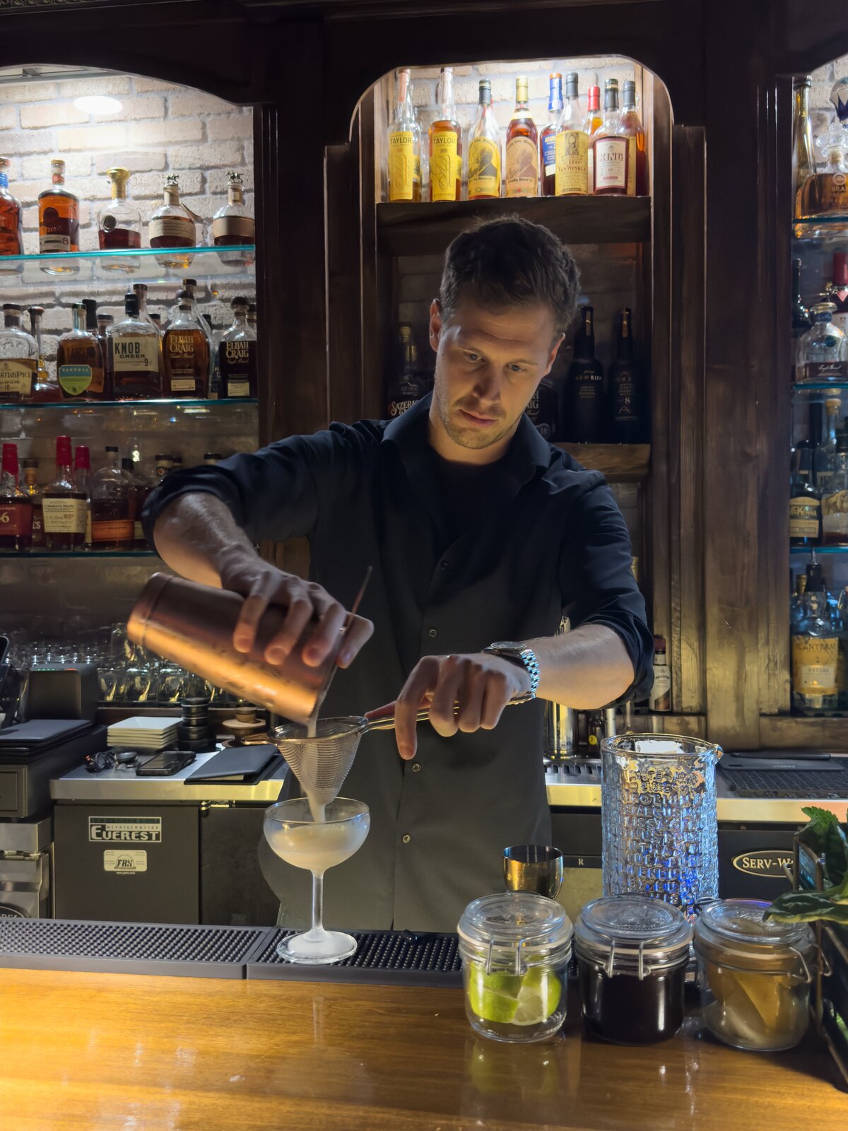 A bartender pours a cocktail at Neat & Noble Bourbon Bar in Nexton