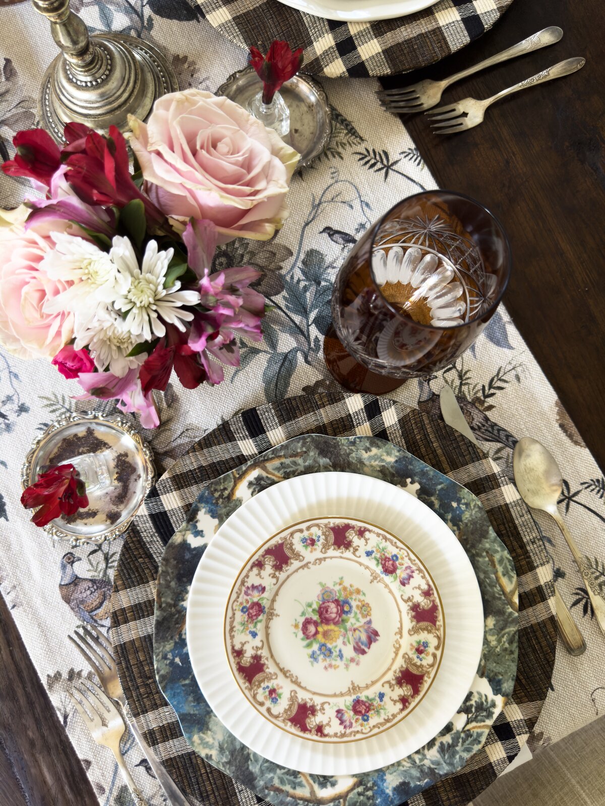 Erin Carlson’s gathered fall table: vintage china on plaid chargers with amber glass and fresh flowers